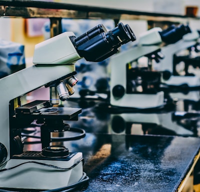 white microscope on top of black table