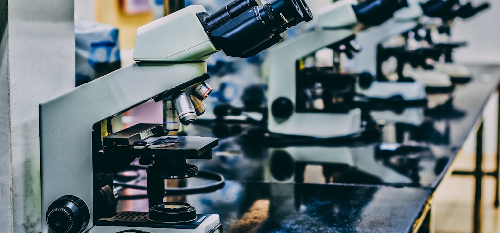 white microscope on top of black table