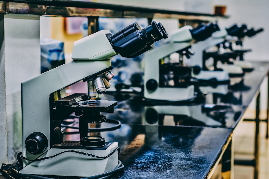 white microscope on top of black table, Microscope