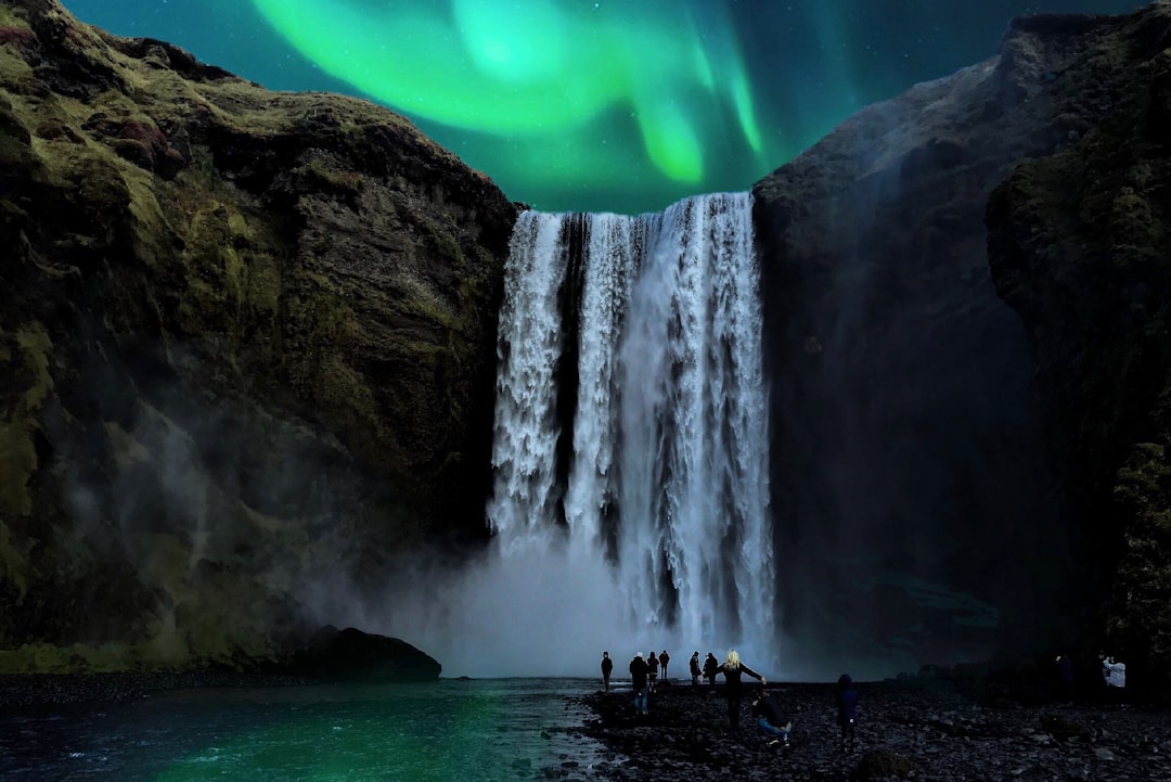 people in the bottom of waterfalls