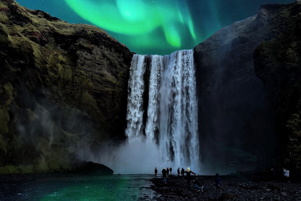 people in the bottom of waterfalls