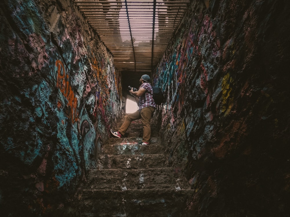 Un hombre subiendo un tramo de escaleras cubierto de graffiti