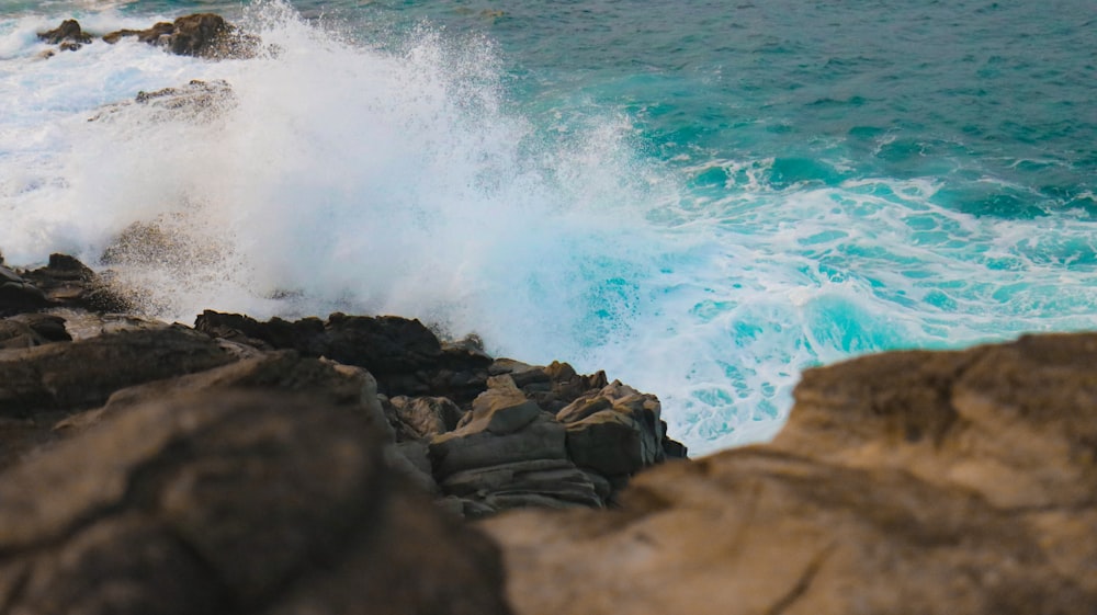 body of water smashed on rock during daytime