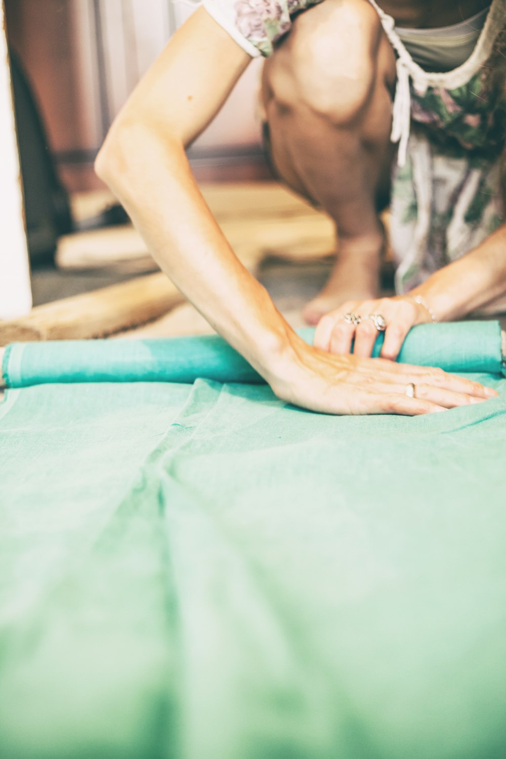 person folding green textile