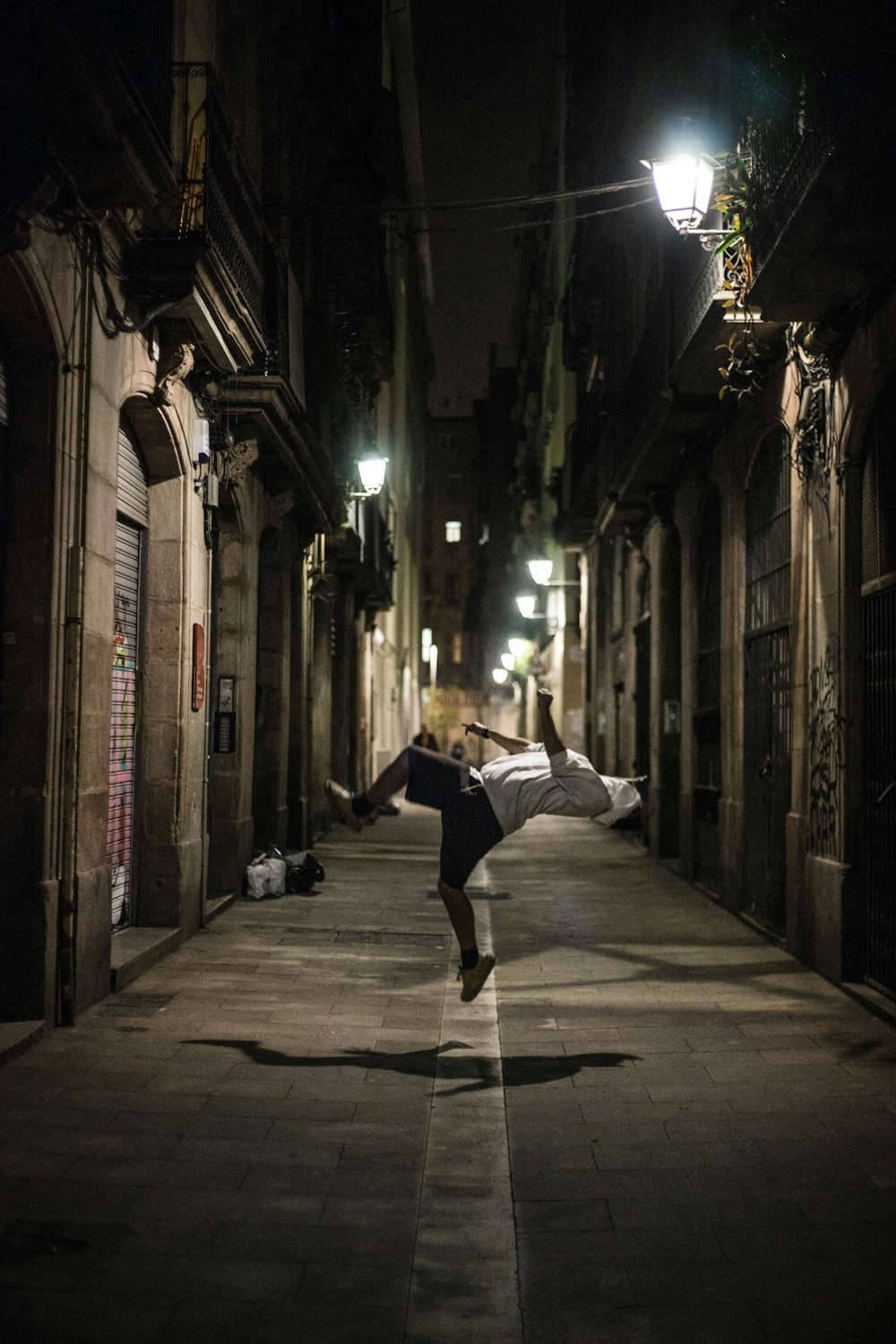 man doing acrobat trick on street