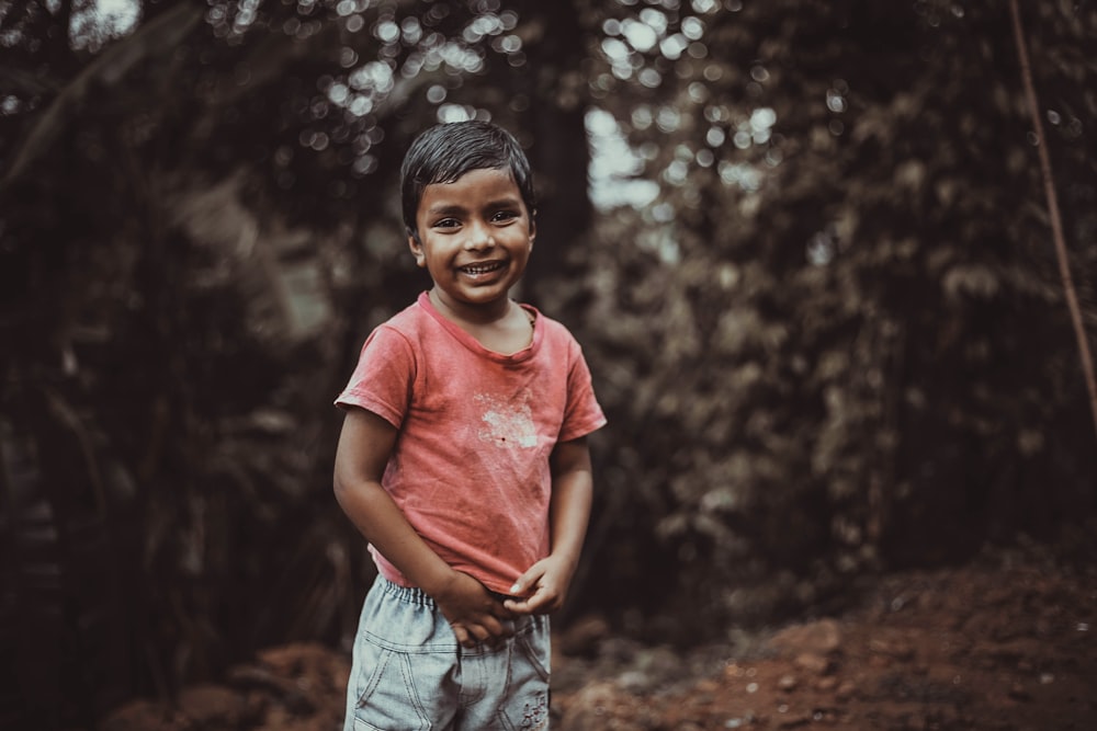 boy wearing red shirt smilinig