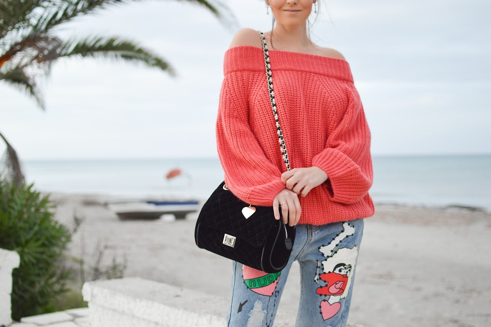 woman wearing long-sleeved top and black sling bag