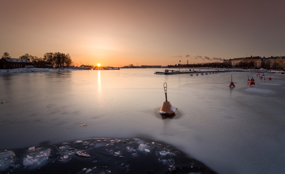 boat on calm water during sunset