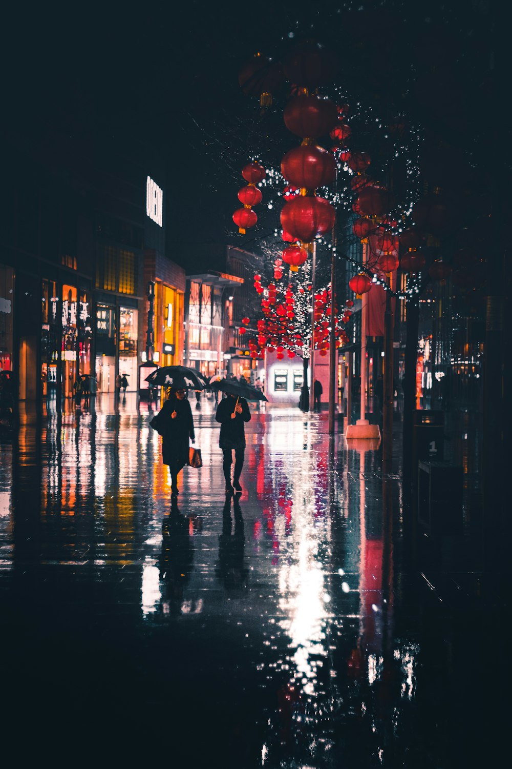 Menschen, die nachts mit einem Regenschirm spazieren gehen