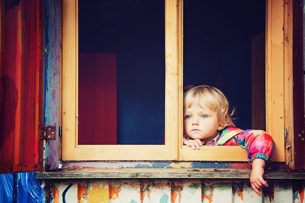 enfant en bas âge regardant la fenêtre