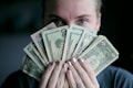 person holding fan of U.S. dollars banknote