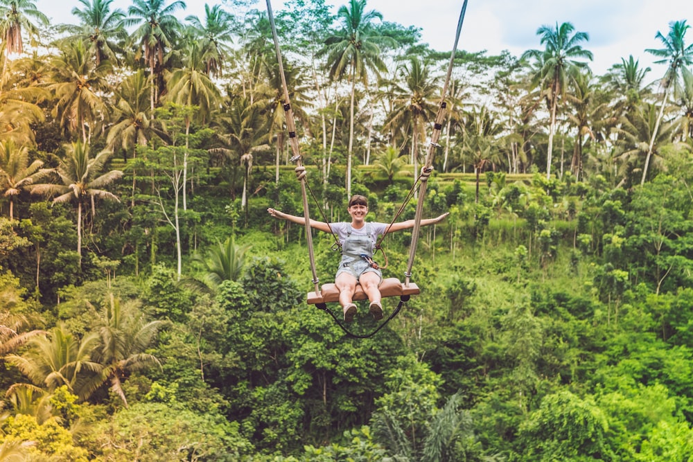 woman in gray T-shirt seating on zipline