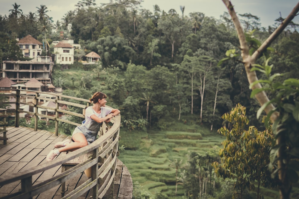 woman sitting near rail