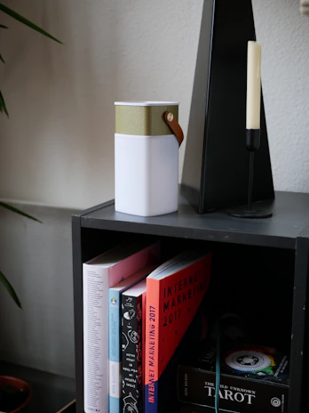 Stylish shelf with black and gold decor items and marketing books.