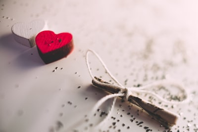 macro shot photography of red and white heart ornament string teams background