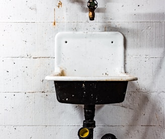 white and black sink beside wall