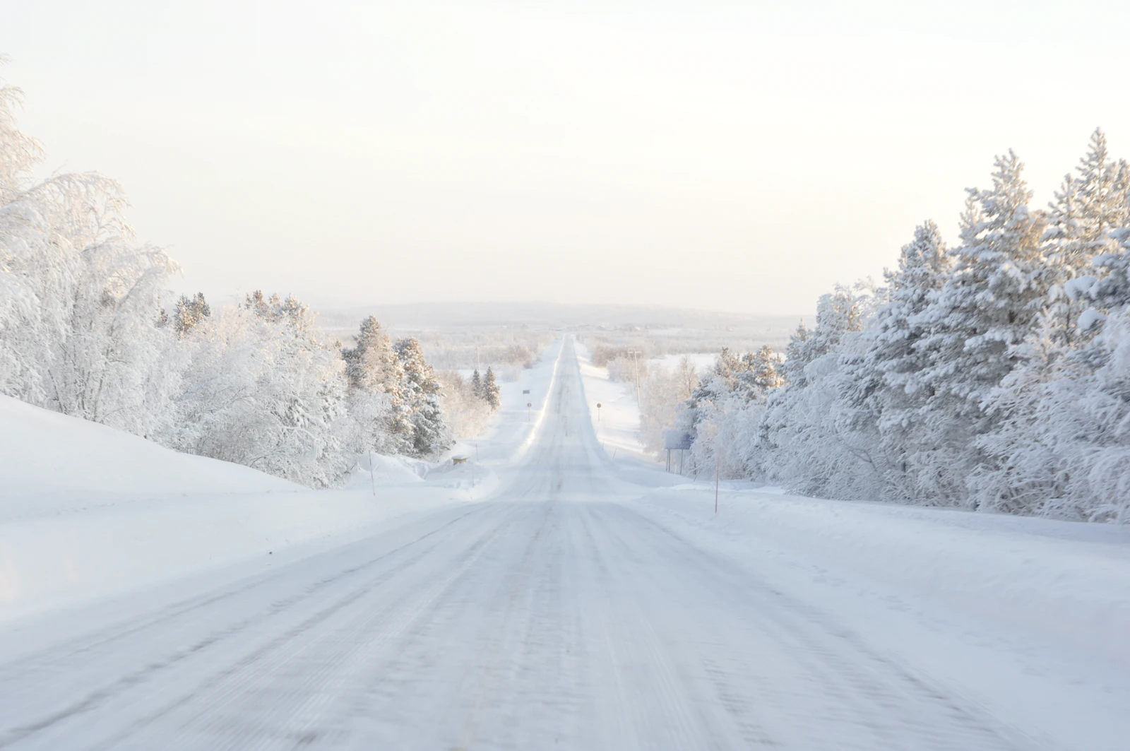 Straight snow-covered road through Finnish Lapland