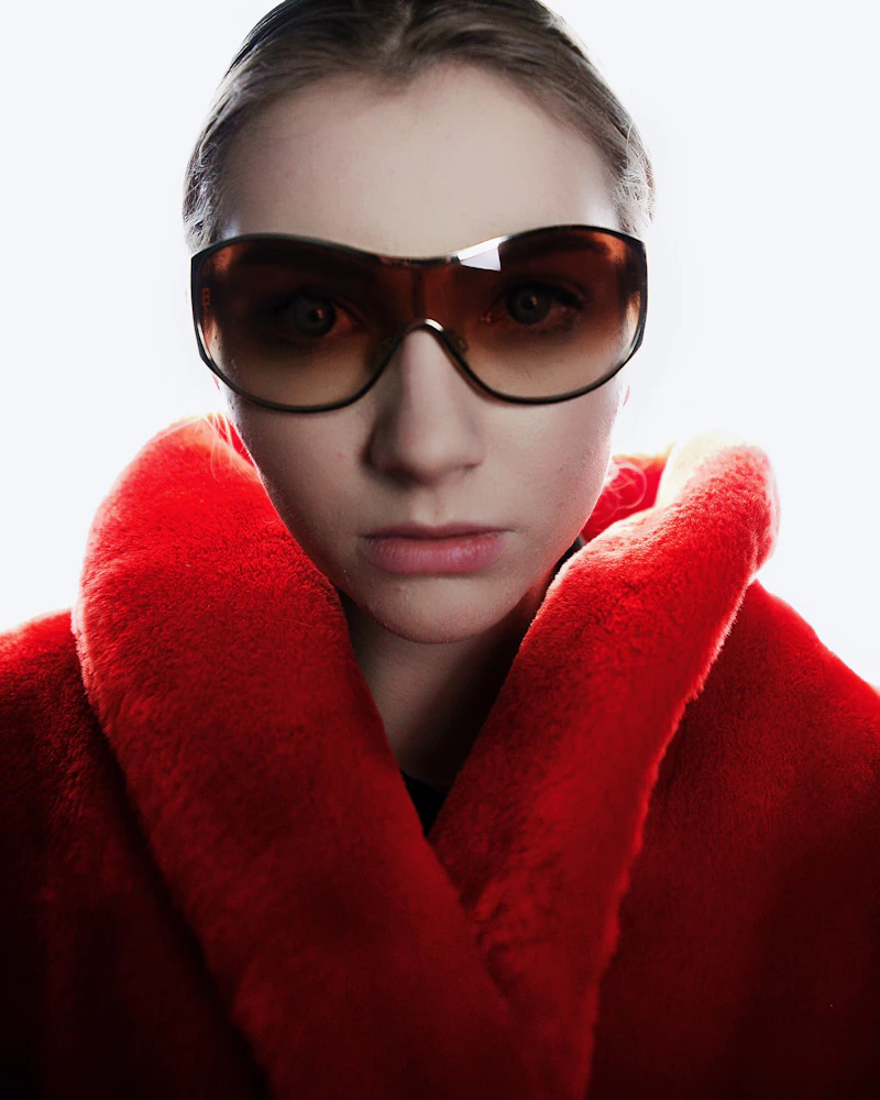Woman in a red coat wearing brown sunglasses
