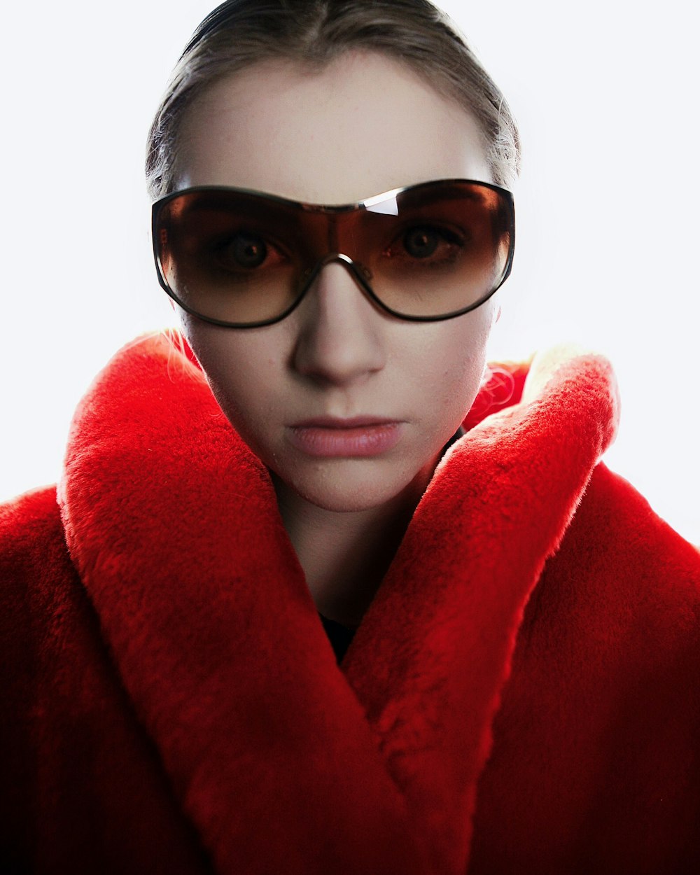 woman in red coat wearing brown sunglasses