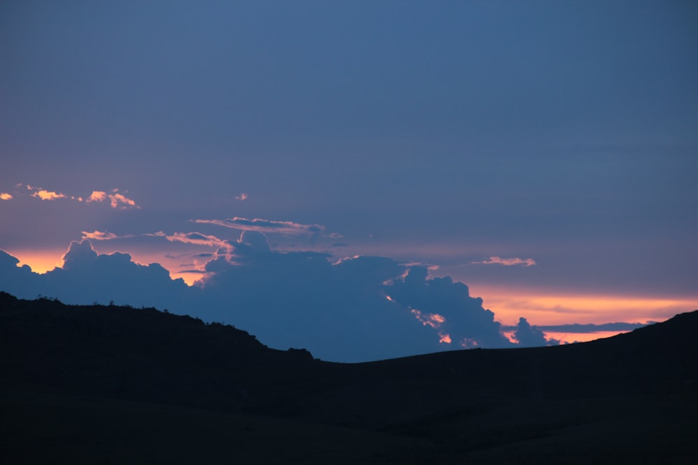 silhouette of a mountain under cloudy sky