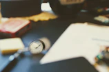 Close-up of a vintage clock and leather-bound ledgers on an executive desk.