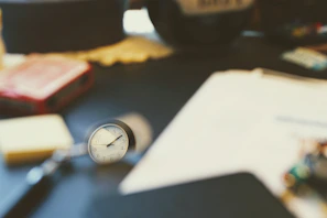 Close-up of a vintage clock and leather-bound ledgers on an executive desk.