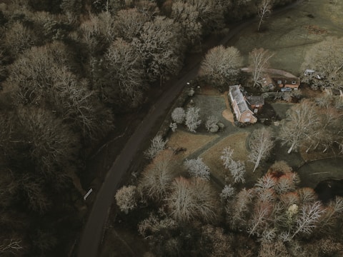 Aerial view of a countryside home nestled among trees and open fields