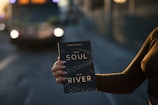 person holding Your Soul is a River book