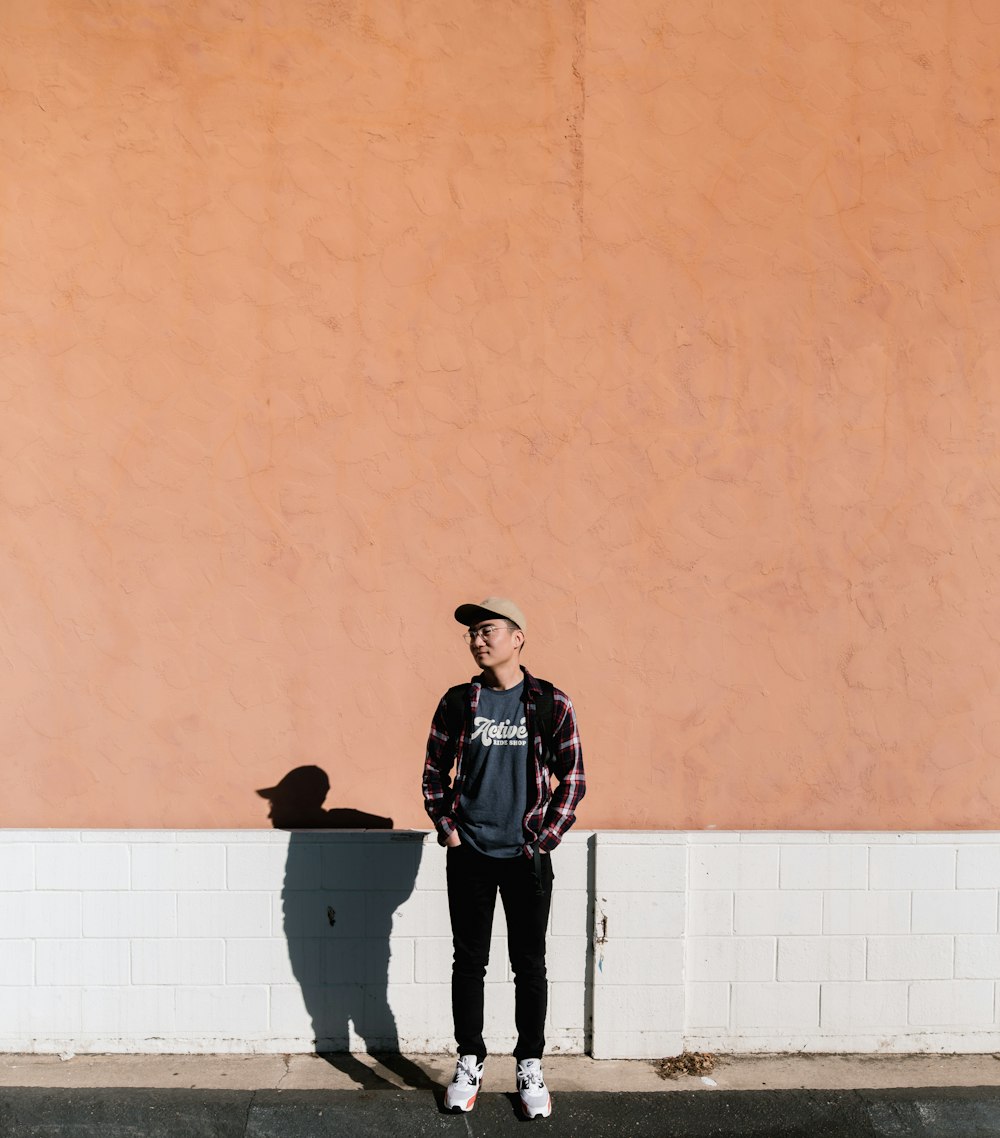 man standing in front of brown wall