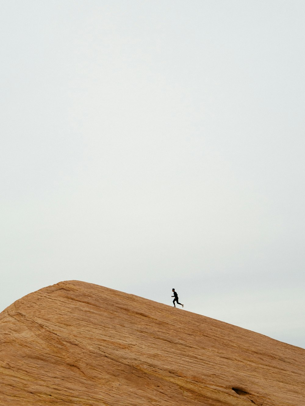 person running on top on hill during daytime