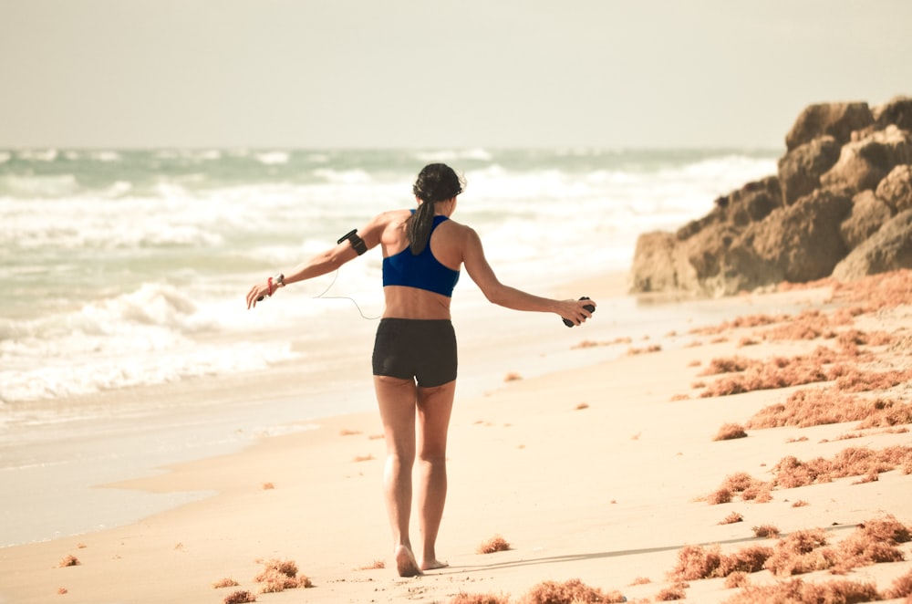 昼間、海岸近くの砂の上を歩く女性