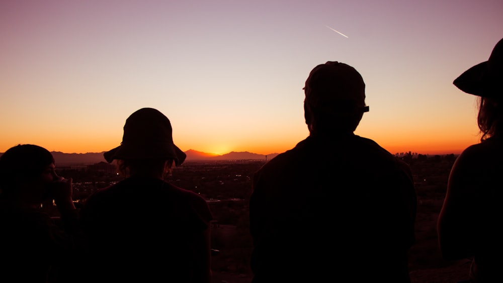 silhouette of four standing people during golden hour