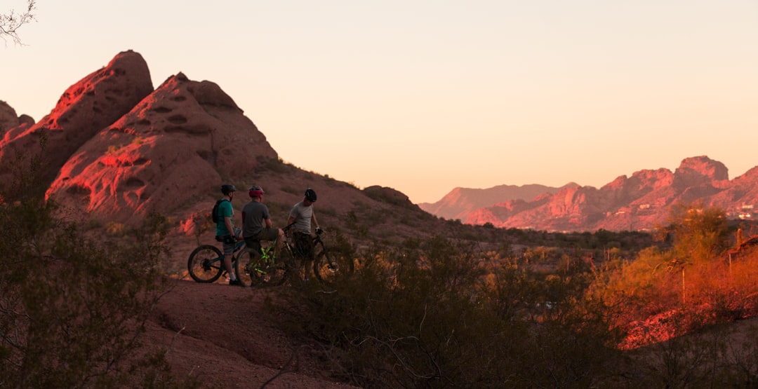 three men with their bicycle looking at rock formations \,
