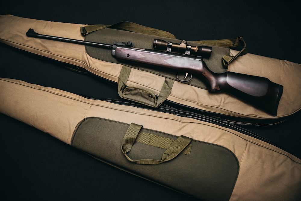 Rifle de francotirador marrón y negro con bolsa beige