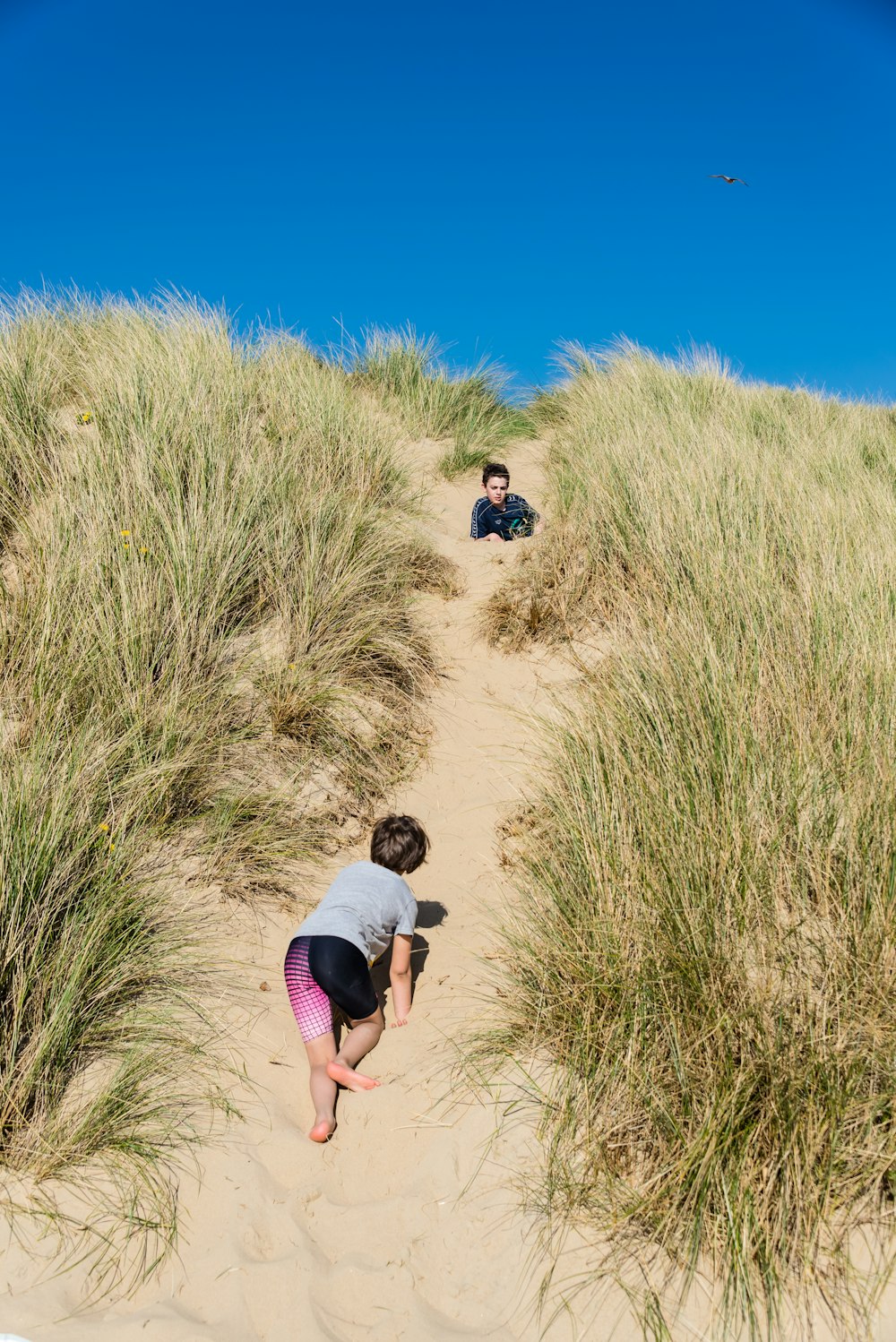 two person climbing on hill during daytime