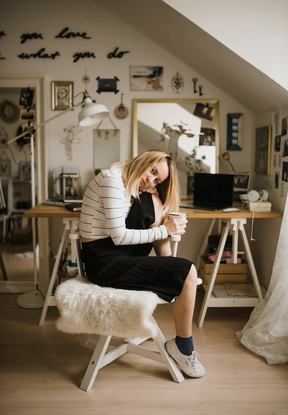 woman sitting on stool resting her head on her knee inside room