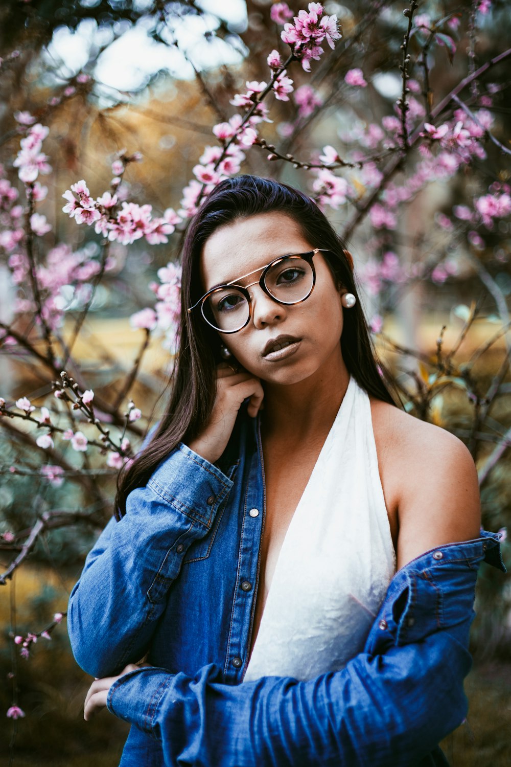 mulher em pé na frente das árvores de flores