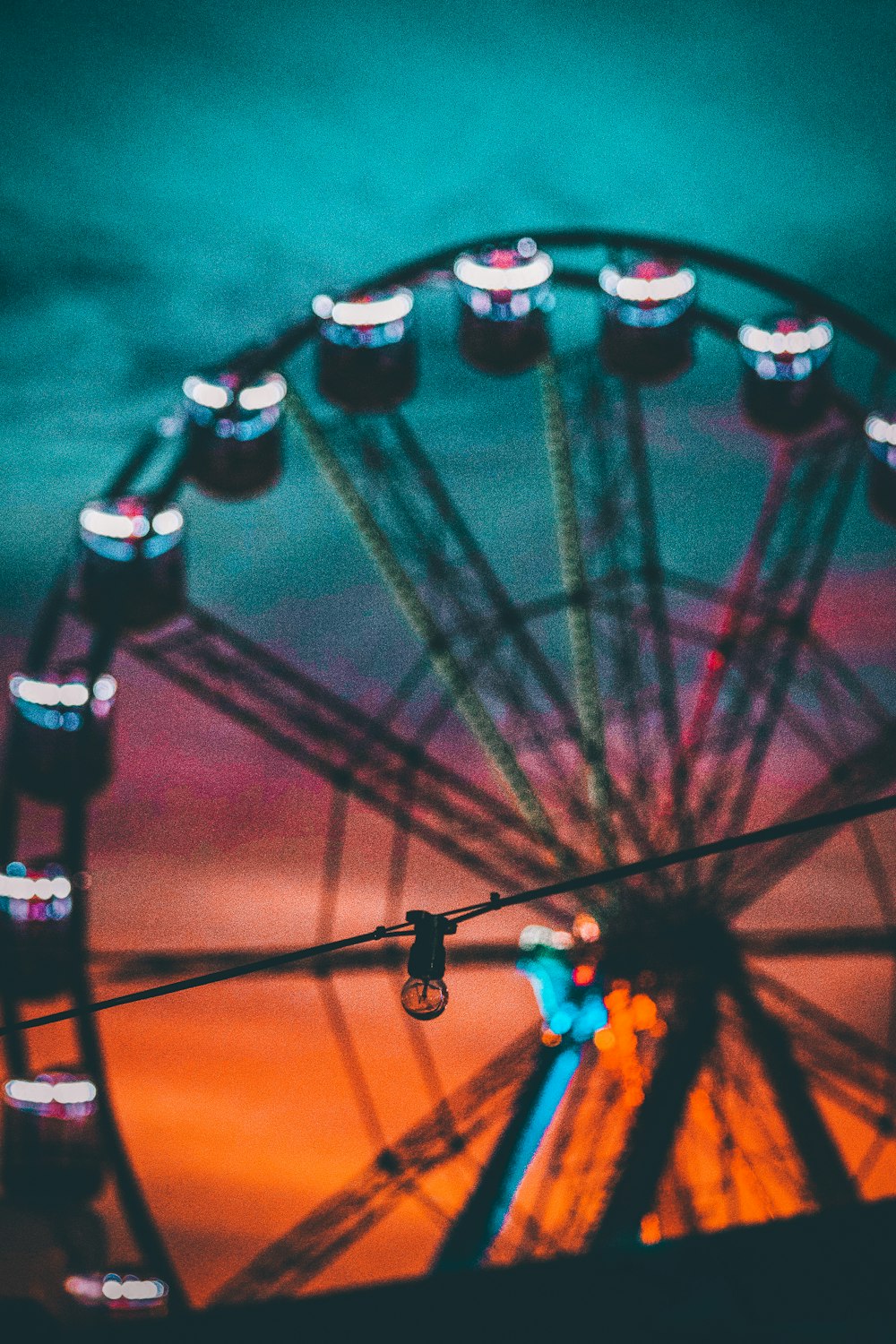 uma roda gigante com um céu colorido no fundo