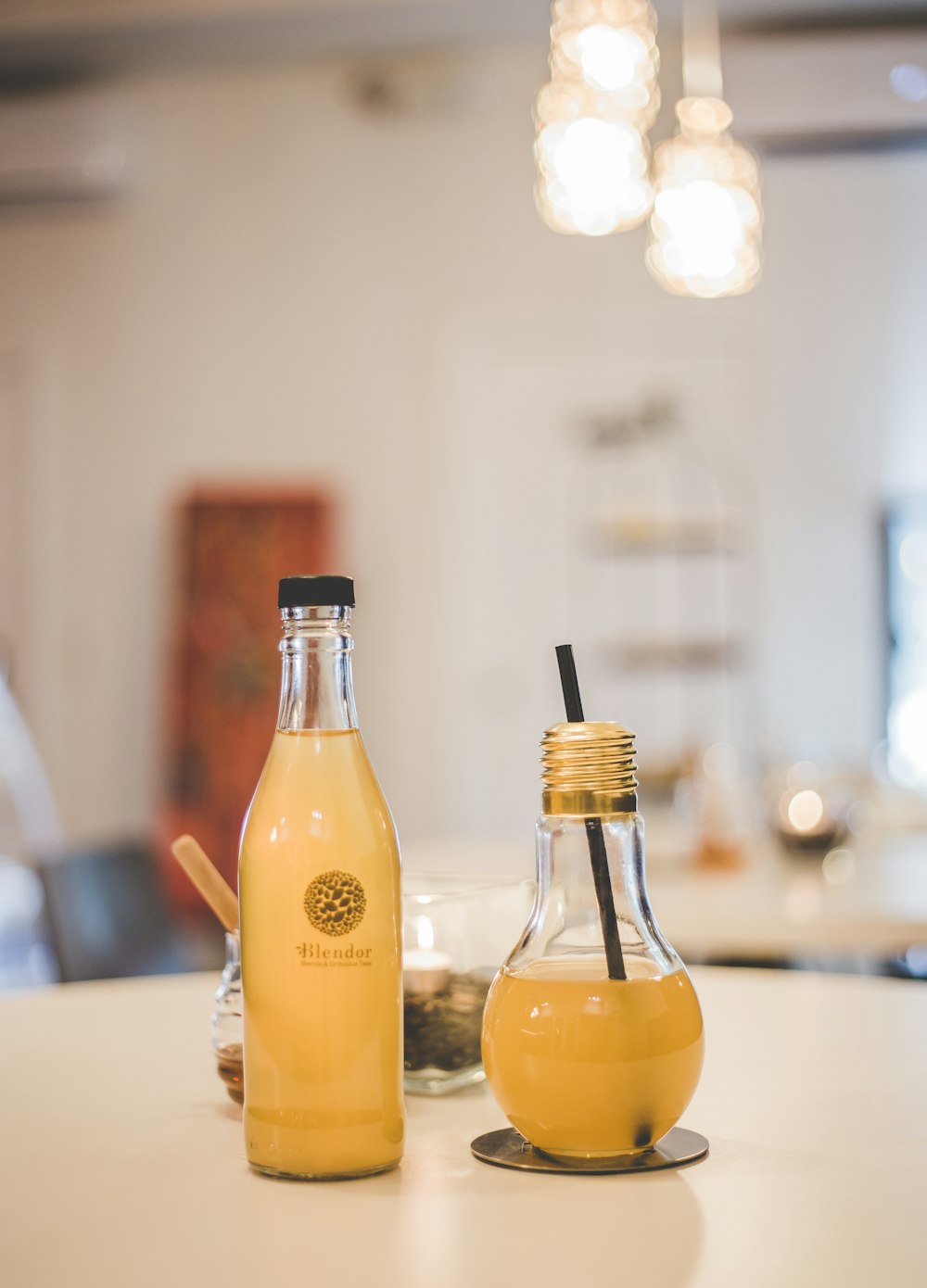 two clear glass bottles with beverage on table