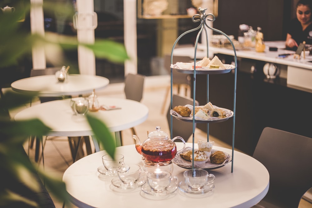 tea set beside gray 3-tier rack on round white table