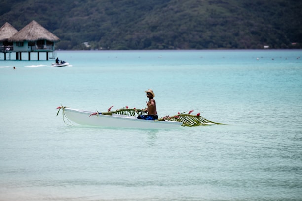 person riding on boat near hut