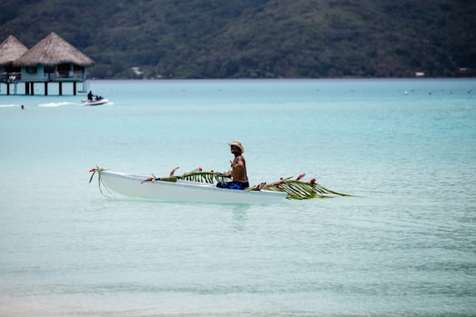 person riding on boat near hut