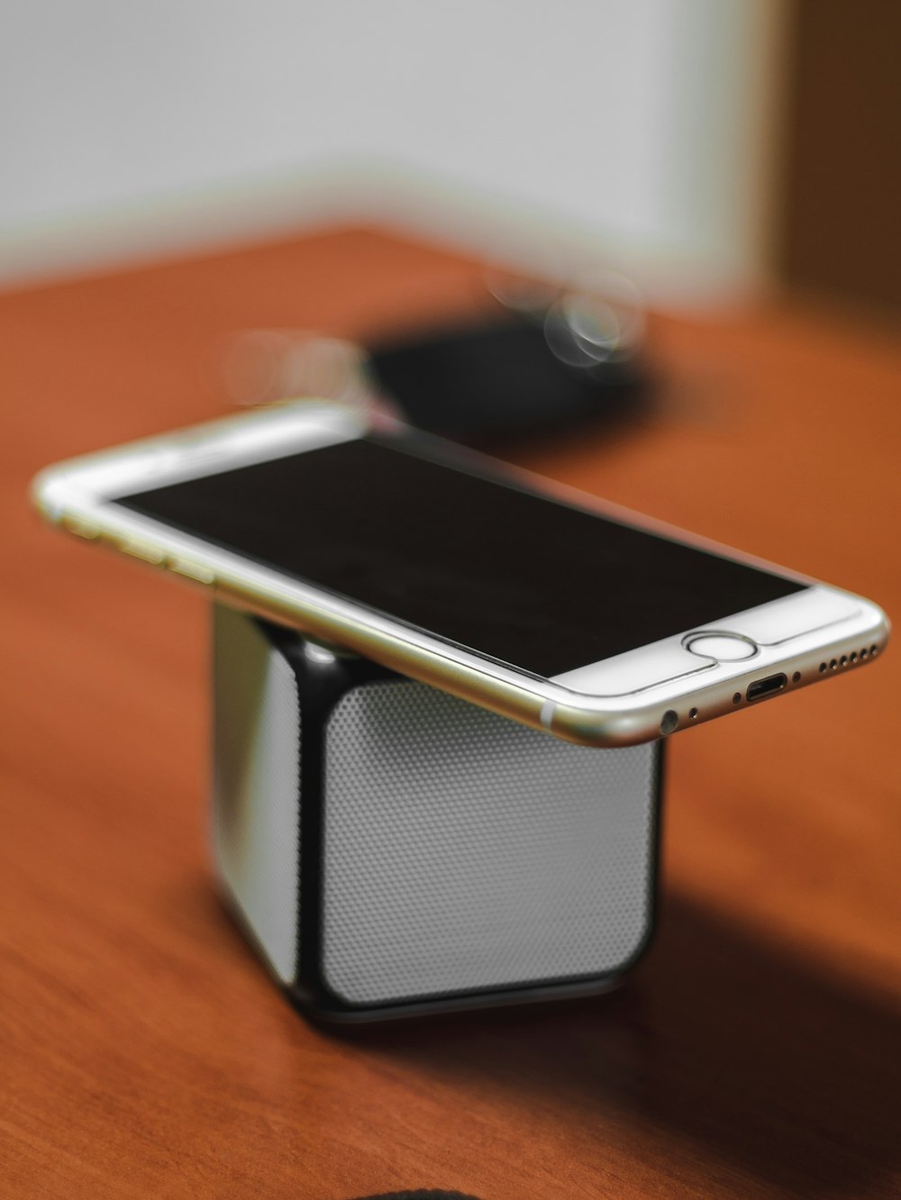 iPhone 6 dourado em cima do alto-falante portátil Bluetooth