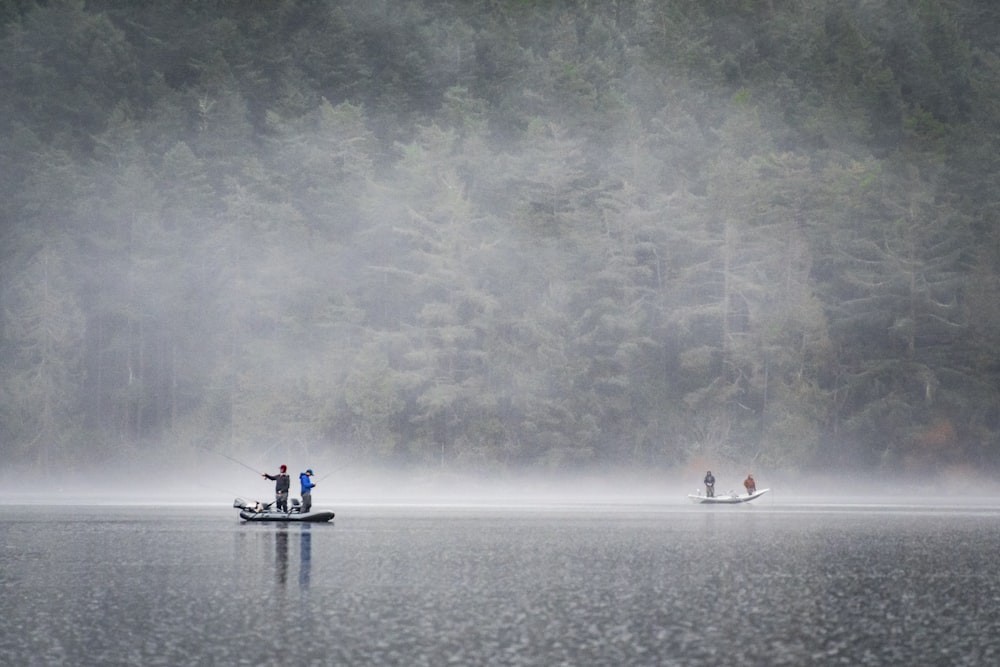 people on boat fishing near foggy forest