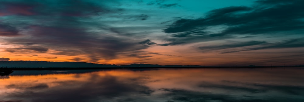 body of water under cloudy sky