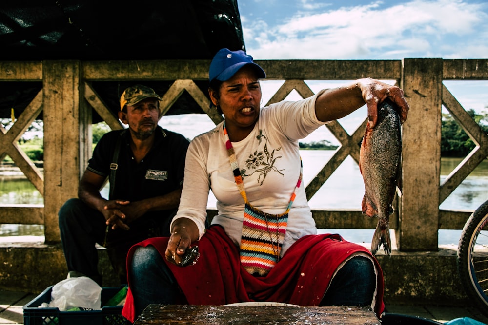 woman holding gray fish