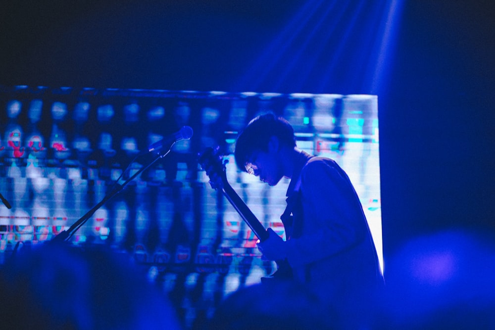 man playing guitar on stage