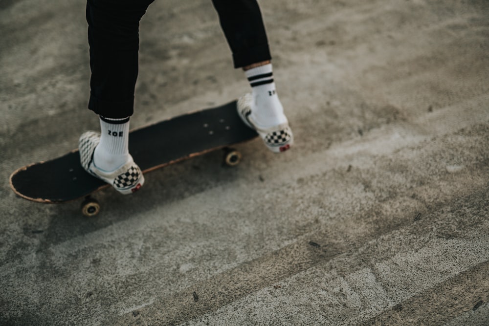 Persona che cavalca sullo skateboard nero durante il giorno