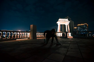 Cinematic penthouse rooftop at night with soft golden lighting and a discreet elegant crowd.