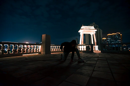 Cinematic penthouse rooftop at night with soft golden lighting and a discreet elegant crowd.